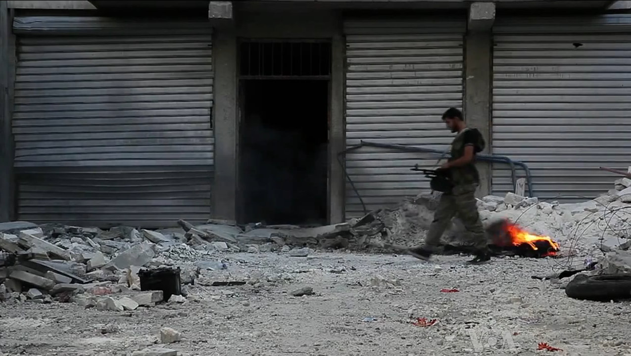 free_syrian_army_soldier_walking_among_rubble_in_aleppo