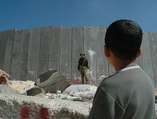 boy_and_soldier_in_front_of_israeli_wall