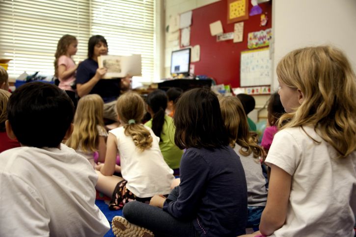 typical-classroom-scene-where-an-audience-of-school-children-were-seated-on-the-floor-725x482