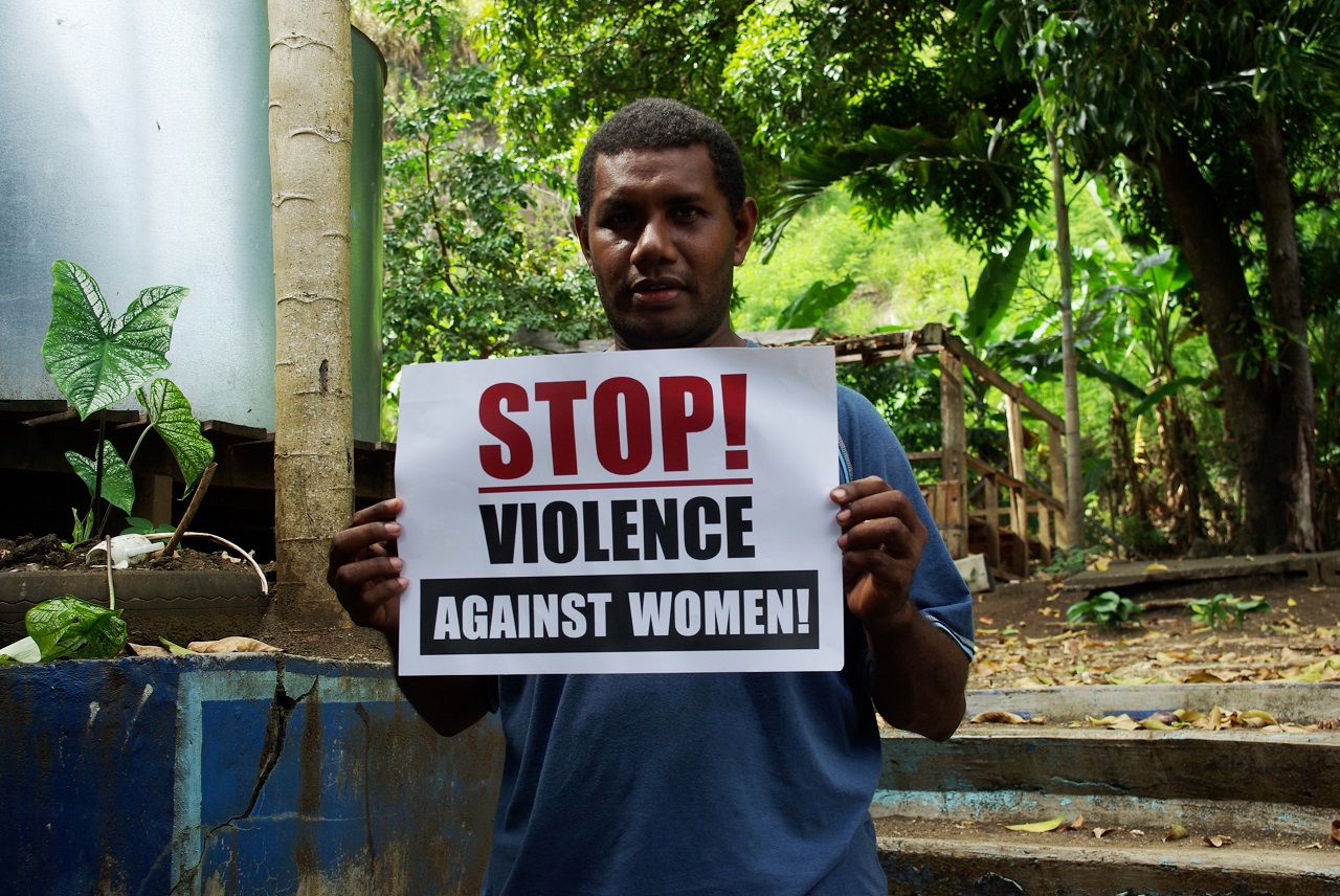 ellison_sau_project_manager_for_the_men_against_violence_against_women_mavaw_program_at_live_and_learn_holding_a_stop_violence_against_women_sign_10694292115