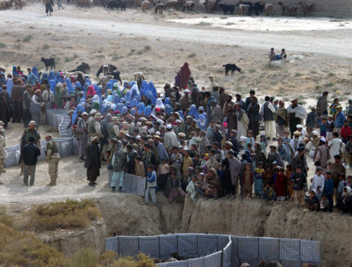 local-villagers-and-refugees-line-up-during-a-humanitarian-aid-program-designed-ff5bd6