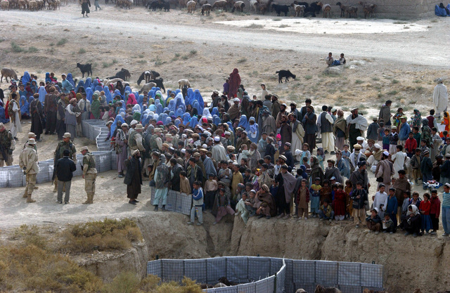 local-villagers-and-refugees-line-up-during-a-humanitarian-aid-program-designed-ff5bd6
